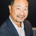 Headshot of Greg Takehara, CEO of Tourism Cares and MC of IMPACT 2025.