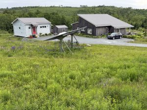 Celes' Passive Design home, his wife's pottery studio and his office, and ground mounted solar panels. Photo by Celes Davar.